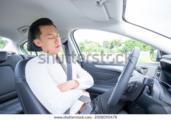 tired\
asian businessman sleep in car while\
commutting