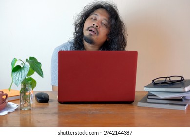 tired asian man sleep in front laptop, funny exhausted man while working at home