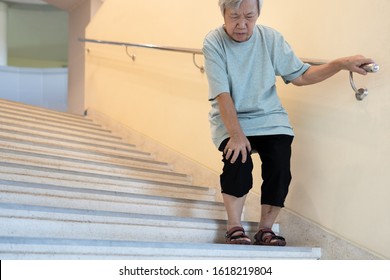 Tired Asian Senior Woman Going Down The Stairs With Leg Pain,touch Her Knee Pain,female Elderly With Acute Knee Joint Pain,physical Injury,exhausted Old People Suffer From Gout,arthritis,rheumatism