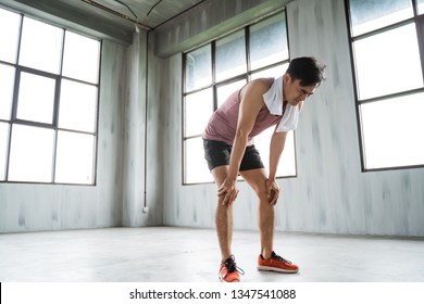 Tired Asian Sport Man Take A Break After High Intensity Workout In The Gym