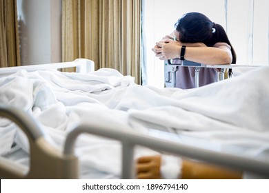 Tired Asian Woman Fell Asleep At The Beside A Patient In A Hospital Bed,physical Fatigue Caused By Overwork Or Stress Of Caring For The Sick Senior,caregiver Taking A Nap With Head Down On Crossed Arm