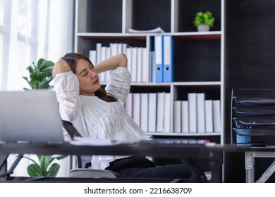 Tired Asian Woman Office Employee Staring At The Laptop Screen, Feels Boring And Melancholy. Bored Eastern Woman In Smart Casual Shirt Sits At The Desk