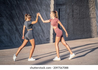 Tired Beautiful Fit Blonde Women Taking A Break, Happy After Outdoor Workout. Two Friends Training Together. Sport. Hobby. Girls With Ideal Slim Bodies. 
