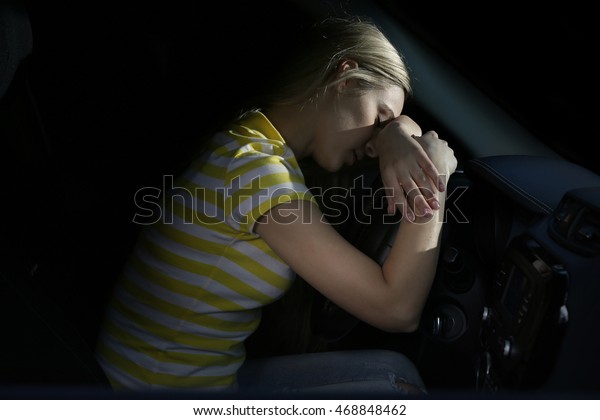 Tired beautiful\
woman falling asleep in\
car