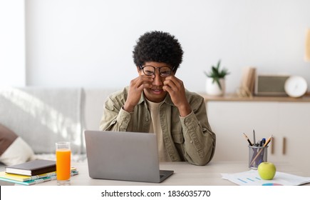 Tired Black Guy Rubbing His Eyes While Studying Online On Laptop At Home, Panorama. African American Male Student Exhausted From Looking At Screen, Doing Assignments Or Communicating On Web