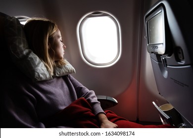 Tired blonde casual caucasian woman sleeping on seat while traveling by airplane on long distance transatlantic flight. Commercial transportation by planes. - Shutterstock ID 1634098174