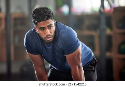 Tired, breathing and fitness gym man taking a break from workout, training or exercising inside a wellness center. Young athletic, masculine guy resting after his strength or muscle exercise session - Powered by Shutterstock