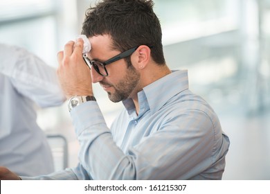 Tired Business Man With Glasses Wiping His Forehead