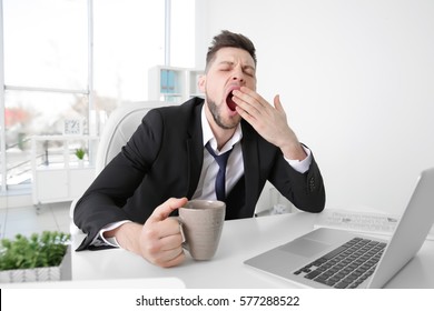 Tired Business Man Yawning At Workplace In Office