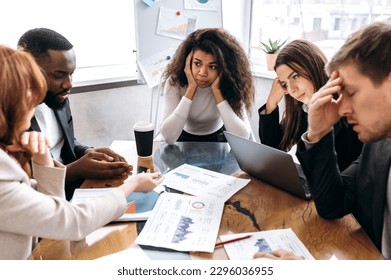 Tired business team are having a briefing meeting, can't find ideas for project. Exhausted male and female employees fail a startup, upset about work troubles, unsuccess and overwork concept - Shutterstock ID 2296036955