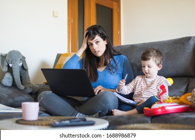 Tired busy woman working on laptop at home with her child. Single mother telecommuting stress.