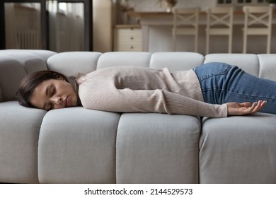Tired calm young woman resting on spacious sofa in home living room, lying on belly, sleeping at daytime, feeling fatigue after stress, sleepless night. Leisure time, recovery concept - Shutterstock ID 2144529573
