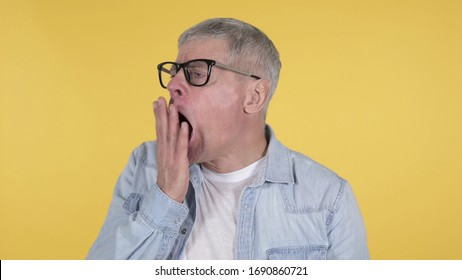 Tired Casual Old Man Yawning On Yellow Background