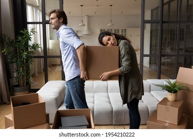 Tired Couple Carrying Cardboard Box, Standing In Modern Living Room, Relocating To New Apartment, Exhausted Young Man And Sleepy Yawning Woman Packing Belongings, Long Hard Moving Day Concept