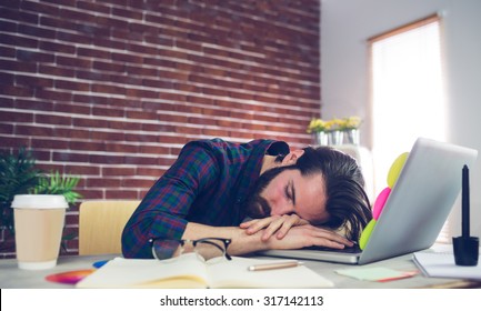 Tired creative editor sleeping on laptop at office - Powered by Shutterstock