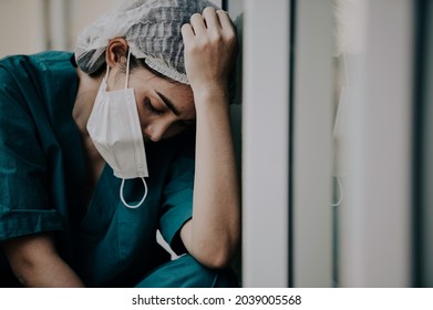 Tired Depressed Female Asian Scrub Nurse Wears Face Mask Blue Uniform Sits On Hospital Floor,Young Woman Doctor Stressed From Hard Work