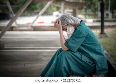 Tired Depressed Female Asian Scrub Nurse Wears Face Mask Blue Uniform Sits On Hospital Floor,Young Woman Doctor Stressed From Hard Work