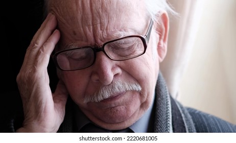 Tired, Depressed Older Gray-haired Man Experiencing Headache And Loneliness. The Old Man Touches His Forehead, Suffers From Severe Headaches. High Quality 4k Video