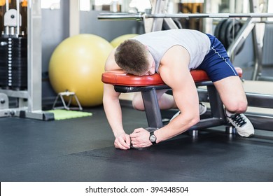 Tired And Desperate Men At The Gym. Male Athlete Lying On A Bench, Exhausted.