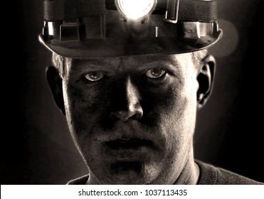 Tired dirty face of coal miner in helmet with light. Detailed portrait of mine worker.