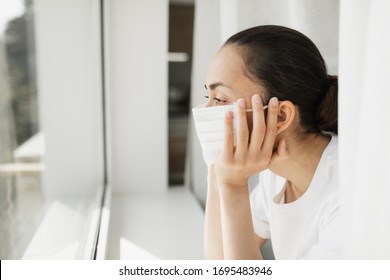 Tired doctor in medical mask looking through window. Important job and self isolation during coronavirus pandemic. Hope for medicine.