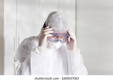 Tired Doctor With Protective Clothing Because Of Coronavirus In A Hospital - Bright White Background