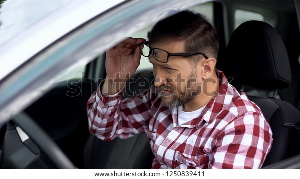 Tired driver taking eyeglasses off, eyesight\
disease, health weakness,\
health