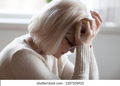 Tired Elderly Woman Suffer From Severe Headache Sitting With Eyes Closed, Exhausted Senior Female Feel Unwell Having Strong Pain Or Dizziness, Upset Aged Lady In Despair Getting Bad Heartbreaking News