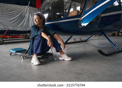 Tired Elegant Female Engineer Is Resting After The Work With Aircraft In Hangar