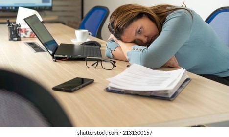 A tired employee experiences a period of burnout at work.Physical and emotional exhaustion of an employee.Burnout concept. - Shutterstock ID 2131300157