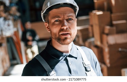 Tired Employee In Uniform Is Working In The Dark Storage.