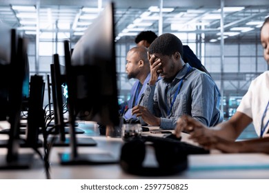 Tired engineer feeling headache while reconfiguring server farm to optimize it for data processing requirements. Stressed man working overtime to ensure data center gear operates efficiently