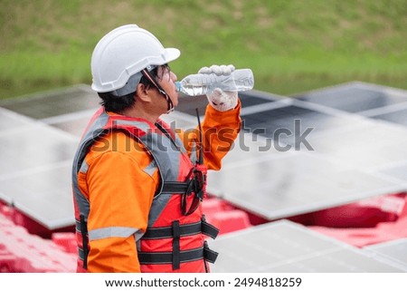 Tired Engineer Worker Man Drinking Water Control Operate Floating Solar Farm Outdoors.