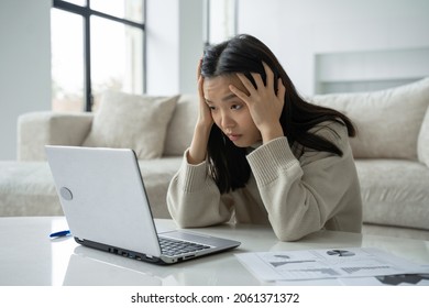 Tired, exhausted Asian woman with a laptop, problems with the project, feeling depressed, laziness in the home office in the living room - Shutterstock ID 2061371372