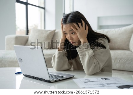 Tired, exhausted Asian woman with a laptop, problems with the project, feeling depressed, laziness in the home office in the living room