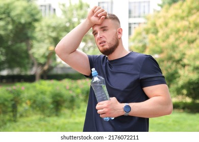 tired exhausted man young fit athletic guy is feeling bad unwell after running, jogging outdoors, having dyspnea, dizziness. suffering from pain, heat, guy with heatstroke. Having sunstroke at summer