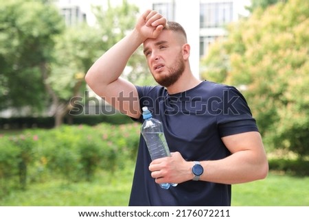 tired exhausted man young fit athletic guy is feeling bad unwell after running, jogging outdoors, having dyspnea, dizziness. suffering from pain, heat, guy with heatstroke. Having sunstroke at summer