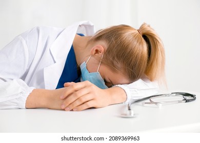 Tired And Exhausted Nurse Or Doctor. Stressed Female Medical Worker With Protective Face Mask, Depressed After Working Over Hours Due To Coronavirus Outbreak. Covid 19. Medicine, Healthcare, Pandemic