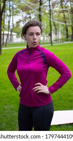 Tired Exhausted Young Brunette Woman In Pink Sportswear Taking A Rest, Break After Hard Workout, Breathing Deep, Standing In Green City Park. Weight Loss Cardio Challenge. Sport Concept. Vertical