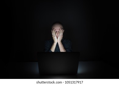 Tired And Exhausted Young Man At Laptop Pc Late In The Evening. Portrait Of Depressed Male Student Or Worker Sitting In Front Of Computer Screen At Night - Concept Of Stress And Overworking 