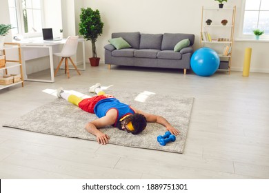 Tired Exhausted Young Sportsman Decided To Take A Break After Failing To Do Push-ups During Sports Workout At Home. Funny Male Athlete Is Lying On Floor After Giving Up Fitness Training With Dumbbells