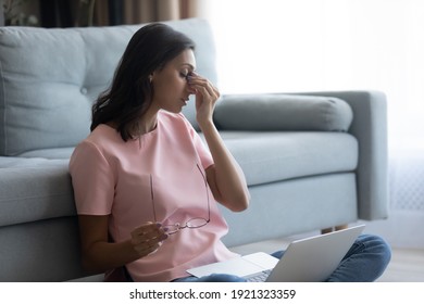 Tired eyes. Fatigued arab female freelancer overworked by pc take glasses off rub nose feel eye strain pain. Young indian woman has vision problem after spending too much time before computer screen