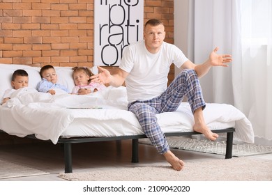 Tired father getting little children to bed at home. Family bedtime