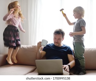 Tired Father With His Two Kids During Quarantine. Stay At Home Concept. Online Working And Household At The Same Time While Quarantine. Exhausted Parents With Children.