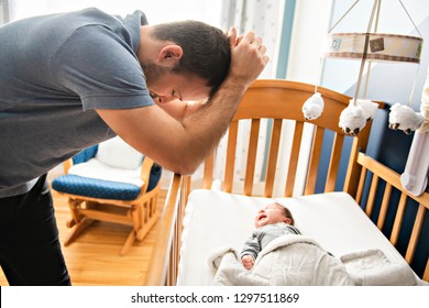 Tired Father With Upset Baby Suffering With Post Natal Depression.