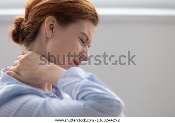 Tired fatigued business woman office worker\
feeling pain chronic discomfort injury hurt rubbing stiff tensed\
sore neck muscles suffer from fibromyalgia ache after sedentary\
work in incorrect posture