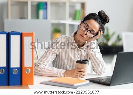 Tired female employee sleeping at work, exhausted woman resting at desk near laptop and folders, napping in the end of hard working day, free space