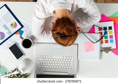 Tired female employee at workplace in office taking nap. Sleepy worker early in the morning after late night work. Creative person (designer or artist) in despair caused by deadline concept - Powered by Shutterstock