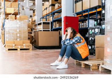 Tired female factory worker taking a break in factory warehouse corridor - Powered by Shutterstock