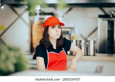 Tired Female Fast Food Worker Resting On A Chair. Unhappy Restaurant Employee Feeling Tired And Bored Having A Break Thinking Of Financial Difficulties On A Minimum Wage
